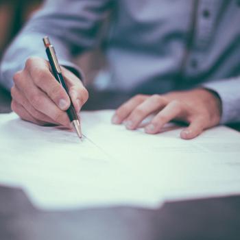 Person writing on a document